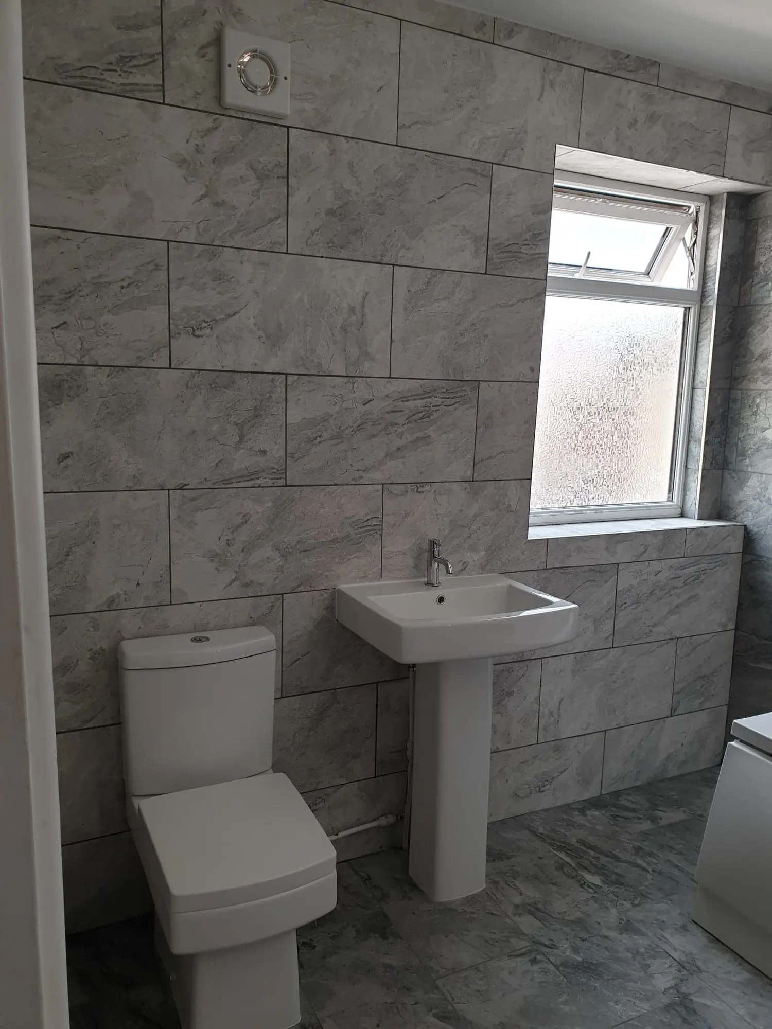 Bathroom with grey marble-effect wall and floor tiles