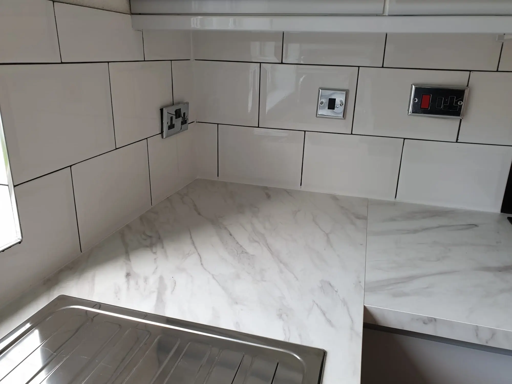Marble-effect worktop with a white gloss tiled splashback