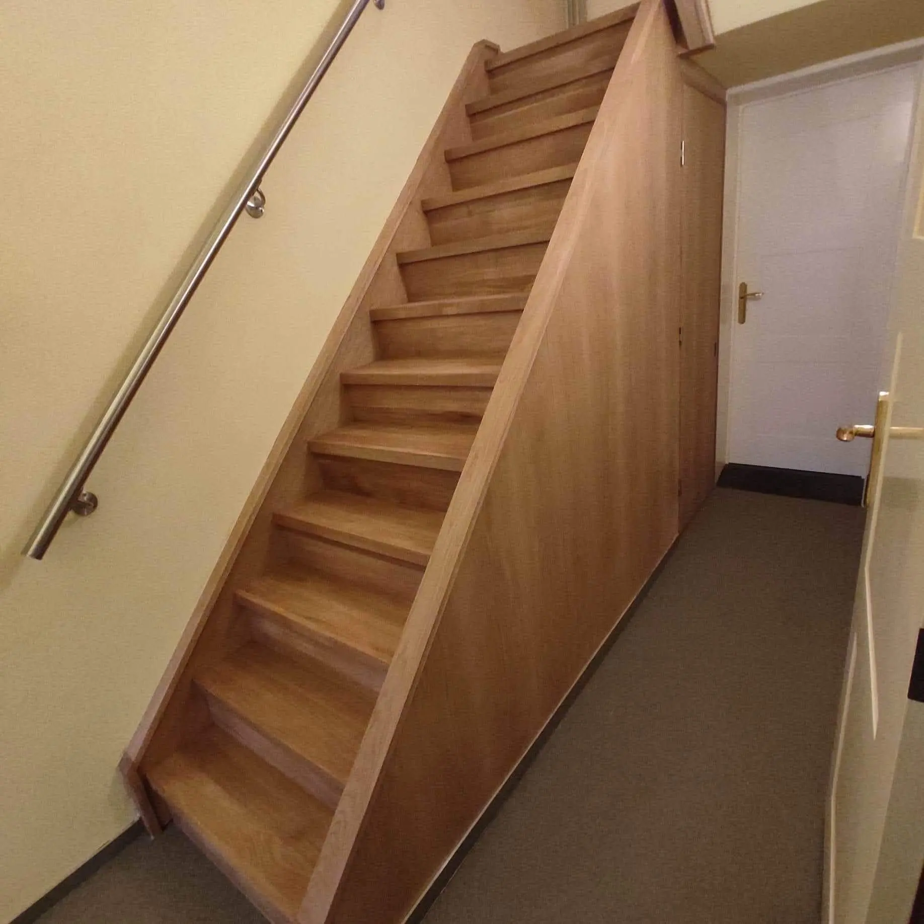 Oak-clad staircase with a steel wall handrail