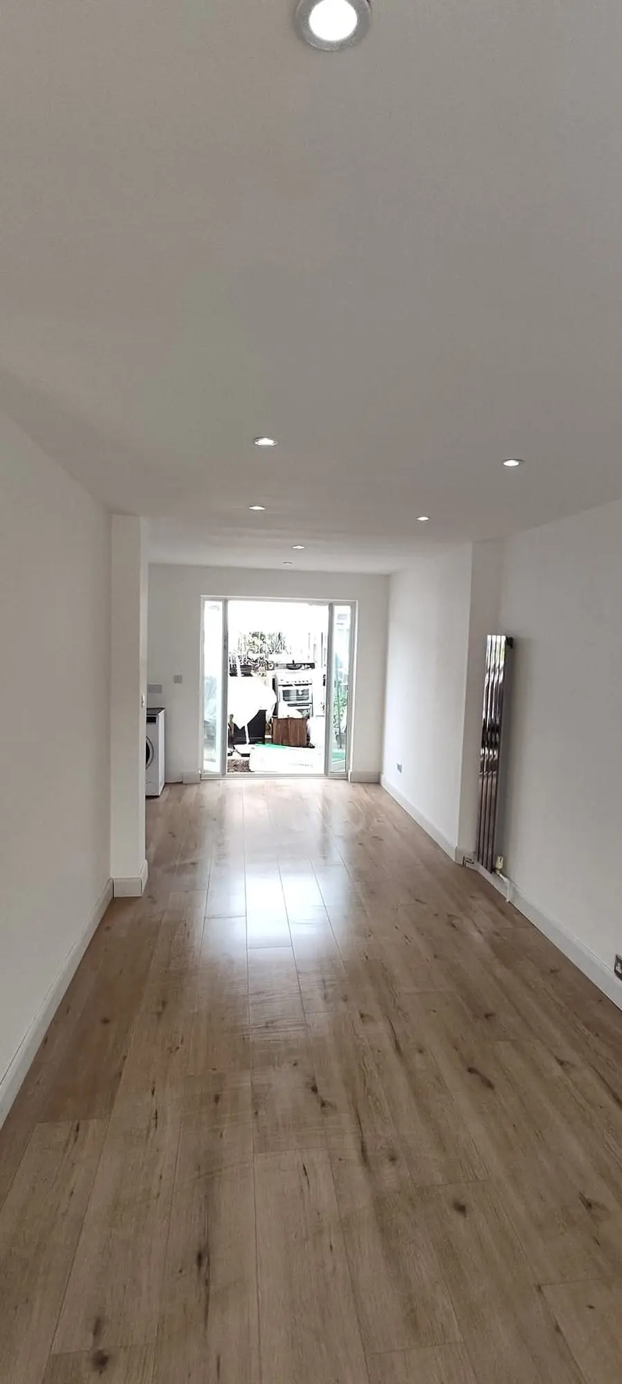 Bright hallway with oak-effect flooring and white walls