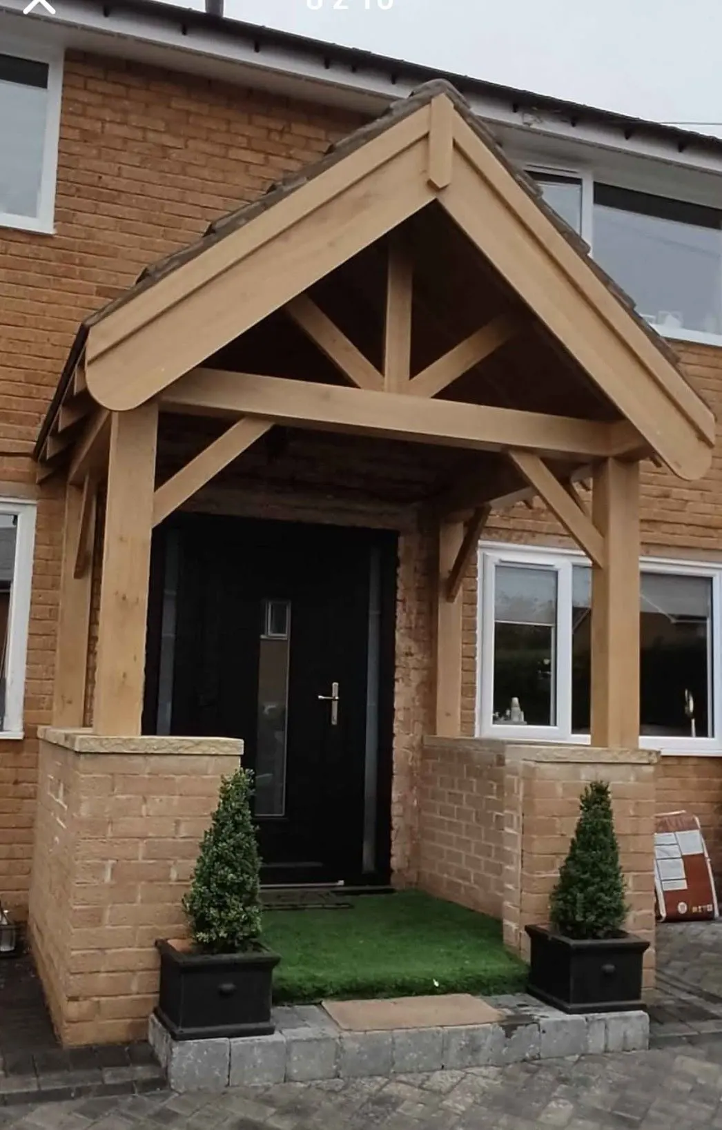 Open oak porch with curved braces and brick side walls